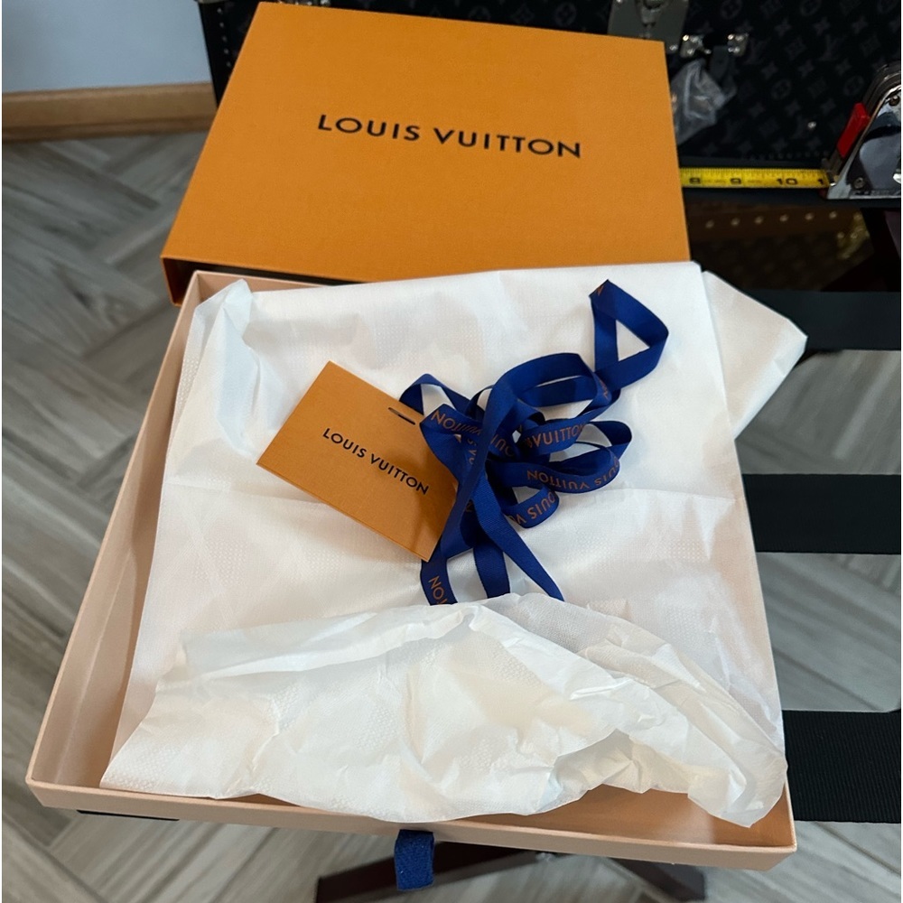 Louis Vuitton box with wrapping paper, ribbon, and Louis Vuitton gift card.​
